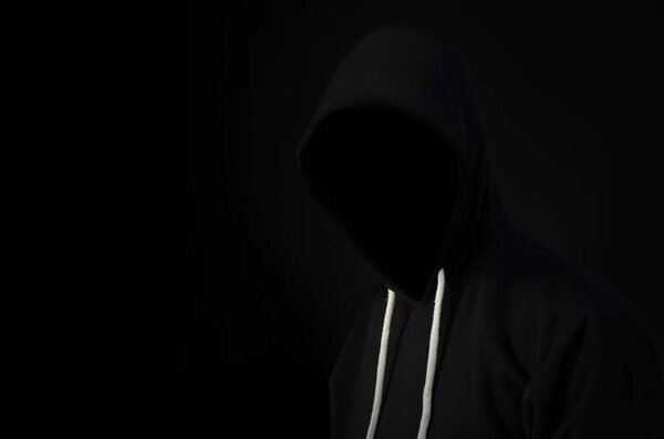 computer hacker in  hoodie. Obscured dark face. Data thief, internet fraud, darknet 