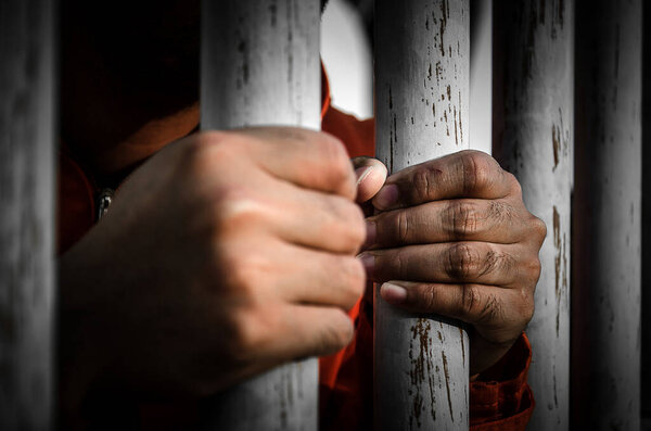 Крупный план мужских рук в тюрьме
