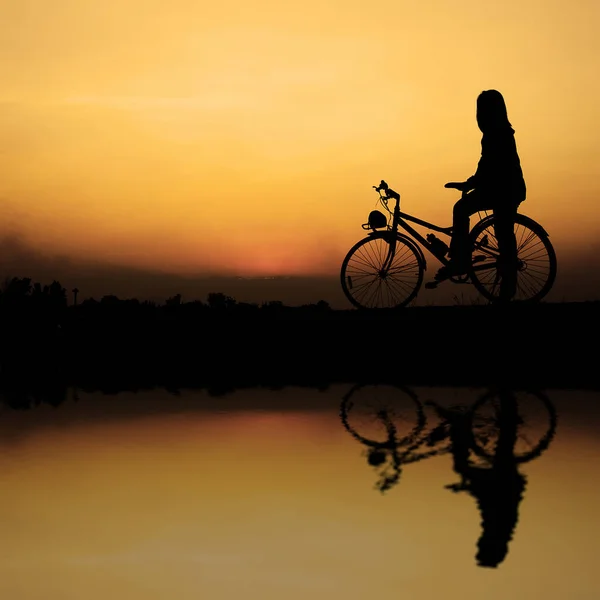 Flicka Ridning Cykel Längs Sjön Vid Solnedgången — Stockfoto