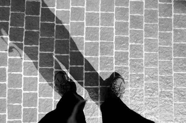 A person\'s shadow on the tiled floor