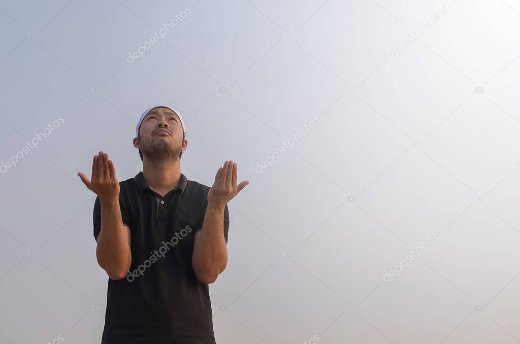Muslim young man praying outside