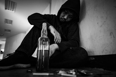 Depresyondaki Asyalı adam sigara içiyor. 
