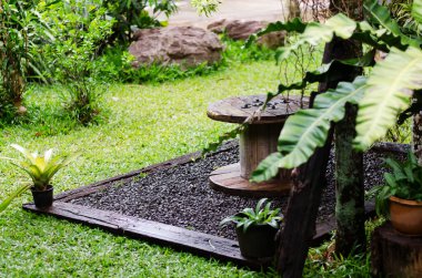 Tahta masa ve yeşil bitkiler arka bahçede. 