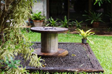 Tahta masa ve yeşil bitkiler arka bahçede. 