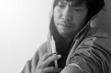 Bağımlı yerde oturuyor ve elinde şırıngayla uyuşturucu alıyormuş.