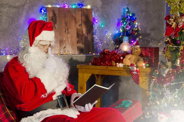 Kerstman Zit Stoel Leest Het Boek Met Een Versierde Kerstboom — Stockfoto