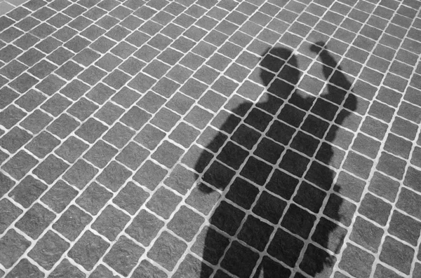 A person\'s shadow on the tiled floor