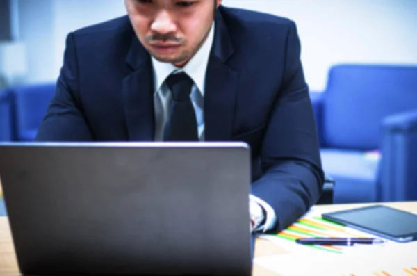 Affärsman sitter med en bärbar dator på sitt kontor — Stockfoto