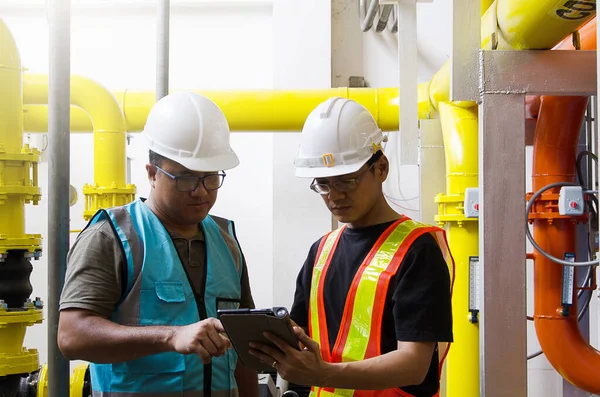 Kıdemli mühendis ve teknisyen sistemin güvenliği için soğutma sisteminin cevaplarını kontrol ediyor.