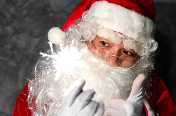 Santa Claus Gospodarstwa Ognie Rękach Szarym Tle — Zdjęcie stockowe