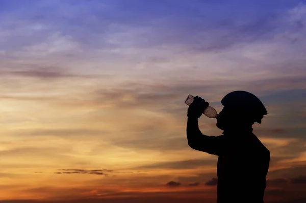 日落时用美丽的水喝水的男人的特写 — 图库照片