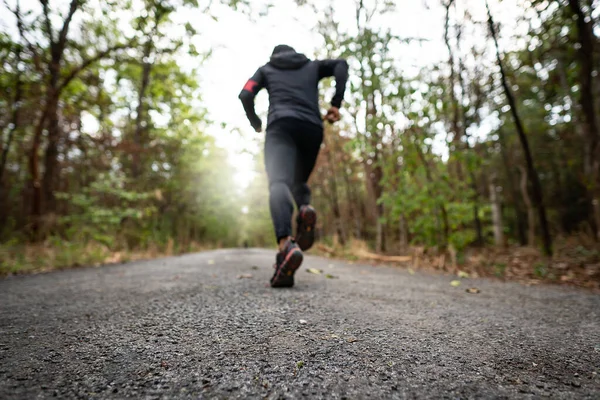 Gün batımının ılık ışığıyla parkta koşan bir koşucu