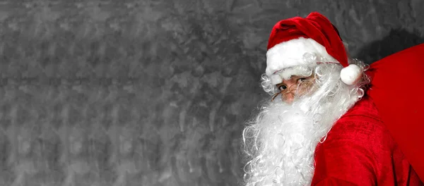 Papai Noel Segurando Saco Grande Seus Ombros Fundo Cinza — Fotografia de Stock