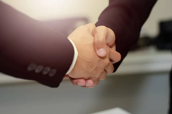 Concept: two businessmen shake hands to congratulate the business