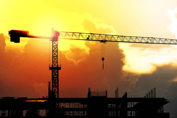 Yapı vinçleri batan güneşin ışığı üzerinde çalışıyor