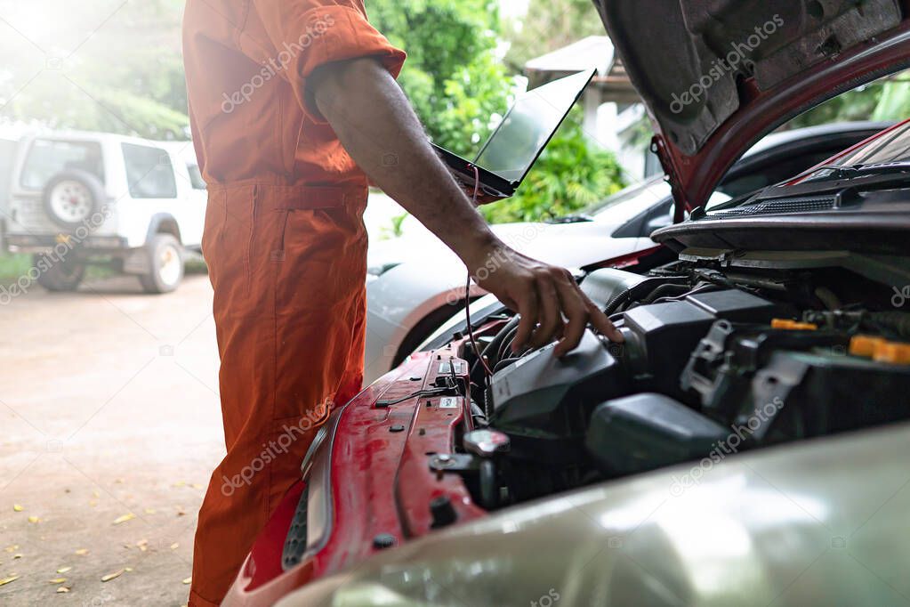 Man mechanic repairing an engine technologies from the laptop