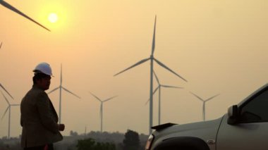 Erkek mühendis rüzgar türbini sistemi teknisyeni hakkında bilgi topluyor, 4K görüntüsü.