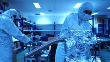 Mühendislerin verileri kontrol edip laboratuardaki aksesuarlar ve senkrotron parçalarıyla yaptıkları çalışmaları tartıştıkları görüntüler.