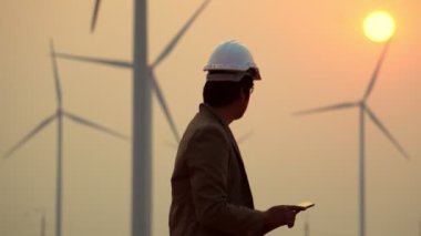 Erkek mühendis rüzgar türbini sistemi teknisyeni hakkında bilgi topluyor, 4K görüntüsü.