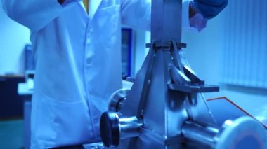 Laboratuvarda aksesuar ve senkrotronun parçalarıyla çalışan mühendislerin görüntüleri.