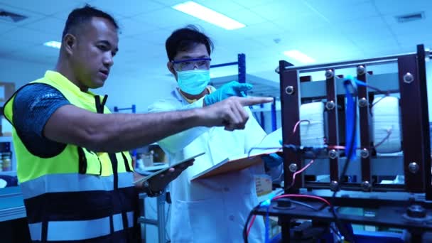 실험실에서 액세서리와 싱크로트론의 일부와 일하는 기술자들의 — 비디오