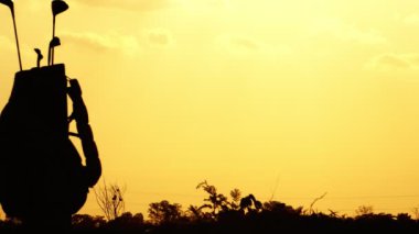 Güzel günbatımında siluet golf atleti