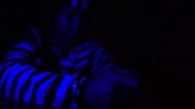 4K görüntülerinde, çizgili üniformalı ve kelepçeli mahkum kendi hatasından dolayı strese girdi, parlak renkli ışıklar.