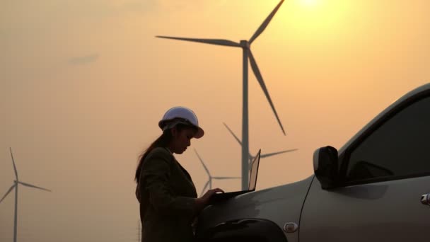 女性技術者が風力発電機の技術者や映像について話しています — ストック動画