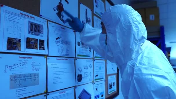 エンジニアがデータを確認し 研究室内の放射光の付属品や部品と作業について話し合う映像 — ストック動画