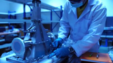 Laboratuvarda aksesuar ve senkrotronun parçalarıyla çalışan mühendislerin görüntüleri.