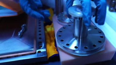 Laboratuvarda aksesuar ve senkrotronun parçalarıyla çalışan mühendislerin görüntüleri.