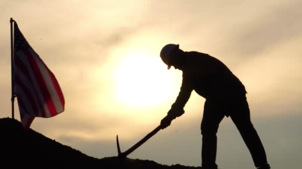 Filmato Operaio Piedi Con Piccone Sulla Collina Tramonto Bandiera Americana — Video Stock