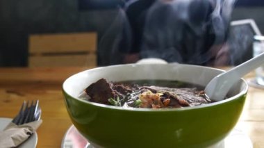 Masada servis edilen sıcak Asya çorbası.
