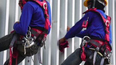 Yüksek ve yüksek katlı pencereleri temizleyen tanınmayan işçilerin görüntüleri