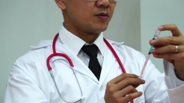 Doctor using a syringe to suck from a bottle of medicine to treat patients footage slow motion