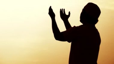 Asyalı Müslüman adamın silueti dua ediyor. 