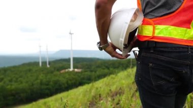 Asian engineers are checking the wind turbine system with a tablet 