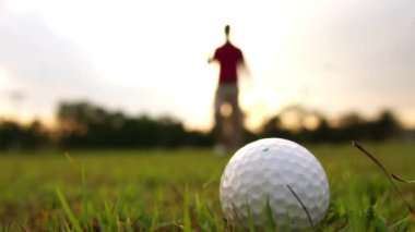 Çayırda golf oynayan Asyalı adam