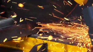 Elektrikli testereyle demir öğüten metal işçisi. 