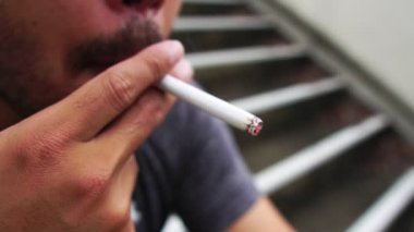 Asyalı erkekler park dışında sigara içiyor. Ağır çekim.