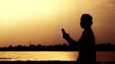 Asyalı Müslüman adamın silueti dua ediyor. 