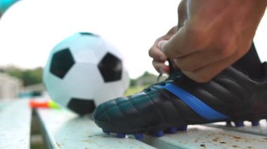 Ayakkabılarını bağlayan bir futbolcunun görüntüleri.