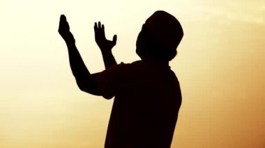Asyalı Müslüman adamın silueti dua ediyor. 