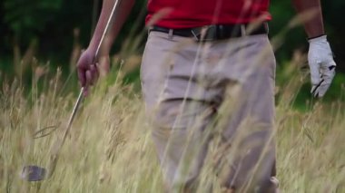 Çayırda golf oynayan Asyalı adam