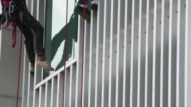 Yüksek ve yüksek katlı pencereleri temizleyen tanınmayan işçilerin görüntüleri