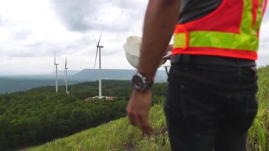 Asian engineers are checking the wind turbine system with a tablet 