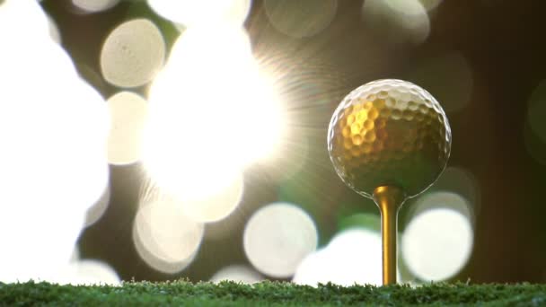 Closeup Πλάνα Από Ηλιοφωτισμένο Χρυσό Μπάλα Του Γκολφ Στο Πράσινο — Αρχείο Βίντεο
