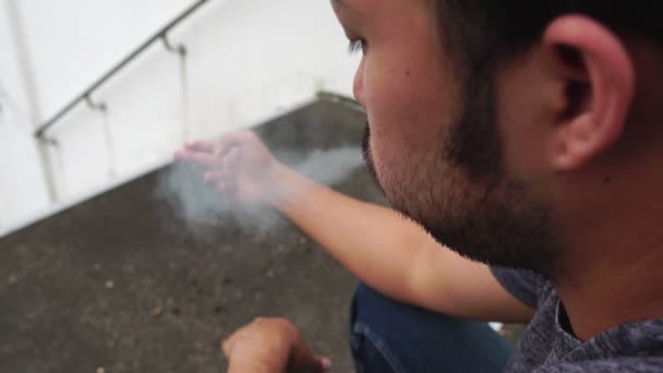 Aasialaiset Miehet Tupakoivat Puiston Ulkopuolella — kuvapankkivideo