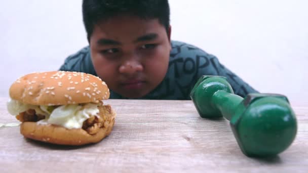 Вибір Товстого Хлопчика Між Бургер Який Робить Гладким Або Гантель — стокове відео