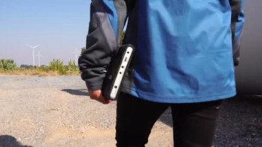 Bir mühendis, rüzgar türbinini tablet görüntüsü 4K ile değerlendirdi.